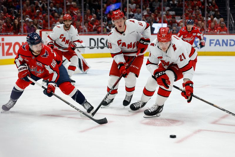 May 15, 2025; Washington, District of Columbia, USA; Washington Capitals left wing Andrew Mangiapane (88) battles for the puck with Carolina Hurricanes right wing Jackson Blake (53) and Hurricanes defenseman Alexander Nikishin (21) in the first period in game five of the second round of the 2025 Stanley Cup Playoffs at Capital One Arena. Mandatory Credit: Geoff Burke-Imagn Images