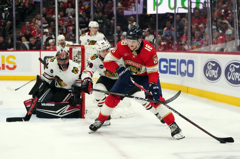 Nov 12, 2023; Sunrise, Florida, USA; Florida Panthers center Steven Lorentz (18) plays the puck in front of Chicago Blackhawks defenseman Wyatt Kaiser (44) during the second period at Amerant Bank Arena. Mandatory Credit: Jasen Vinlove-USA TODAY Sports