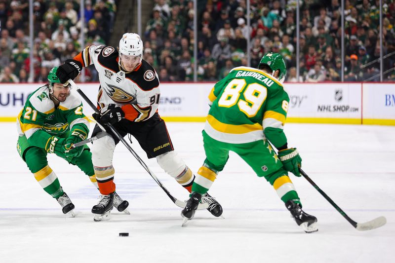 Jan 27, 2024; Saint Paul, Minnesota, USA; Anaheim Ducks center Leo Carlsson (91) skates with the puck as Minnesota Wild right wing Brandon Duhaime (21) and center Frederick Gaudreau (89) defend during the first period at Xcel Energy Center. Mandatory Credit: Matt Krohn-USA TODAY Sports