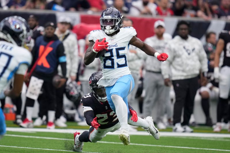 Tennessee Titans tight end Chig Okonkwo (85) runs past Houston Texans safety Eric Murray (23) after a catch to score a touchdown during the second half an NFL football game Sunday, Nov. 24, 2024, in Houston. (AP Photo/Eric Christian Smith)