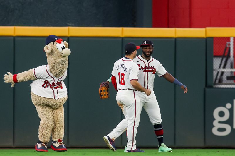 Sep 24, 2024; Atlanta, Georgia, USA; Atlanta Braves left fielder Ramon Laureano (18) and center fielder Michael Harris II (23) celebrate after a victory over the New York Mets at Truist Park as mascot Blooper looks on. Mandatory Credit: Brett Davis-Imagn Images
