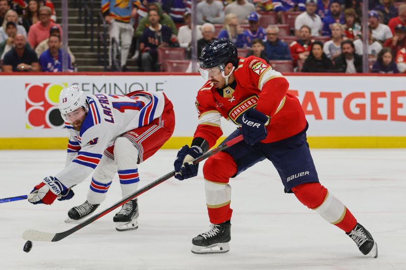 May 28, 2024; Sunrise, Florida, USA;Florida Panthers center Evan Rodrigues (17) moves the puck against the New York Rangers during the second period in game four of the Eastern Conference Final of the 2024 Stanley Cup Playoffs at Amerant Bank Arena. Mandatory Credit: Sam Navarro-USA TODAY Sports