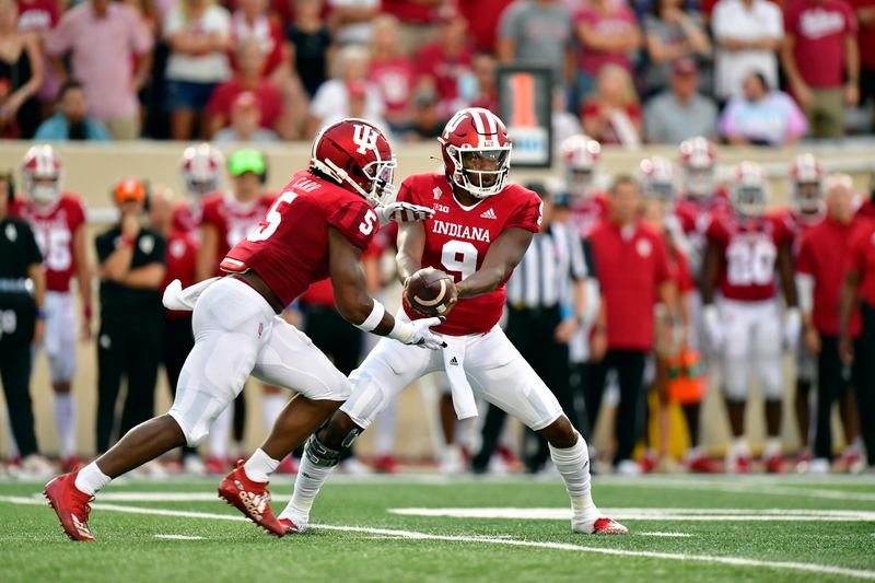 Sep 11, 2021; Bloomington, Indiana, USA; Indiana Hoosiers quarterback Michael Penix Jr. (9) hands the ball off to running back Stephen Carr (5) against the Idaho Vandals during the first quarter at Memorial Stadium. Mandatory Credit: Marc Lebryk-USA TODAY Sports