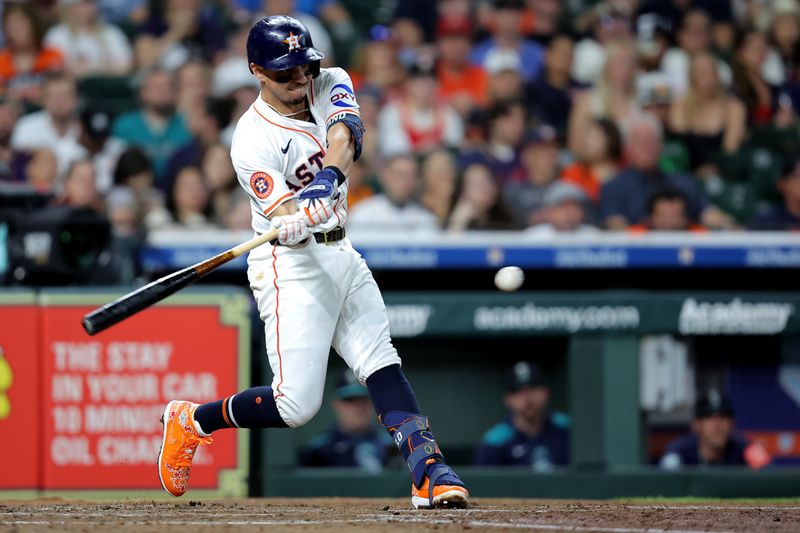 May 22, 2025; Houston, Texas, USA; Houston Astros second baseman Mauricio Dubon (14) hits a single against the Seattle Mariners during the third inning at Daikin Park. Mandatory Credit: Erik Williams-Imagn Images