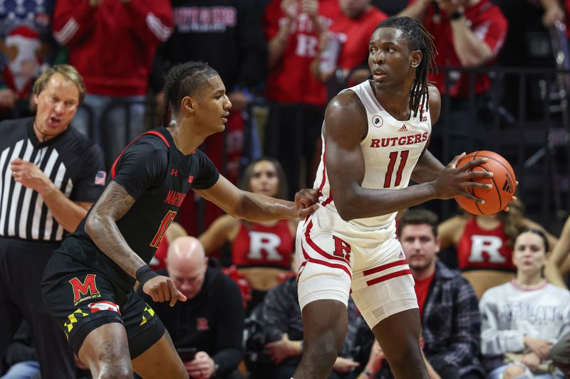 Jan 5, 2023; Piscataway, New Jersey, USA; Rutgers Scarlet Knights center Clifford Omoruyi (11) shields the ball from Maryland Terrapins forward Julian Reese (10) during the first half at Jersey Mike's Arena. Mandatory Credit: Vincent Carchietta-USA TODAY Sports