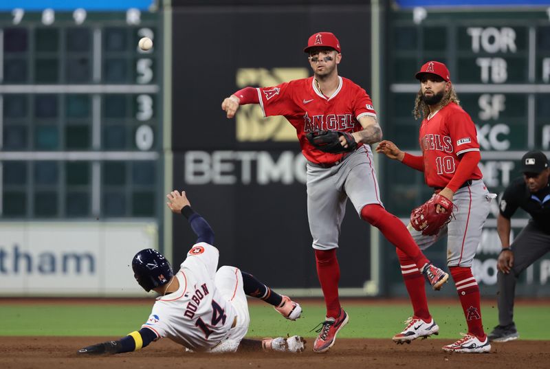 Sep 21, 2024; Houston, Texas, USA; Los Angeles Angels shortstop Zach Neto (9) turns a double play against Houston Astros left fielder Mauricio Dubon (14) in the fourth inning at Minute Maid Park. Mandatory Credit: Thomas Shea-Imagn Images