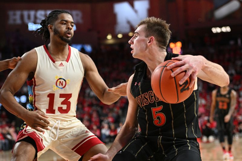 Feb 11, 2023; Lincoln, Nebraska, USA;  Wisconsin Badgers forward Tyler Wahl (5) drives against Nebraska Cornhuskers forward Derrick Walker (13) in the second half at Pinnacle Bank Arena. Mandatory Credit: Steven Branscombe-USA TODAY Sports