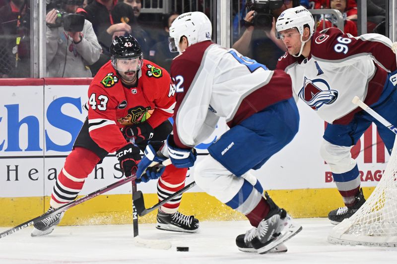 Dec 19, 2023; Chicago, Illinois, USA; Chicago Blackhawks forward Colin Blackwell (43) passes the puck from behind the net as Colorado Avalanche defenseman Josh Manson (42) and forward Mikko Rantanen (96) defend in the first period at United Center. Mandatory Credit: Jamie Sabau-USA TODAY Sports