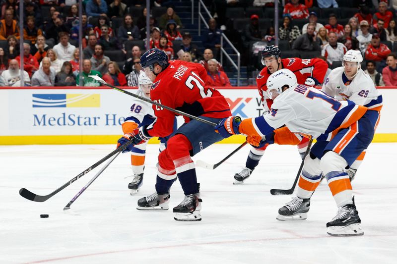 Oct 31, 2025; Washington, District of Columbia, USA; Washington Capitals center Aliaksei Protas (21) skates with the puck against as New York Islanders defenseman Matthew Schaefer (48) and Islanders center Bo Horvat (14) defend during the third period at Capital One Arena. Mandatory Credit: Geoff Burke-Imagn Images