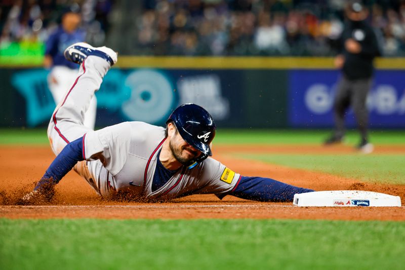 Apr 30, 2024; Seattle, Washington, USA; Atlanta Braves catcher Travis d'Arnaud (16) slides into third base on a sacrifice fly by right fielder Ronald Acuna Jr. (13, not pictured) against the Seattle Mariners during the eighth inning at T-Mobile Park. Mandatory Credit: Joe Nicholson-USA TODAY Sports