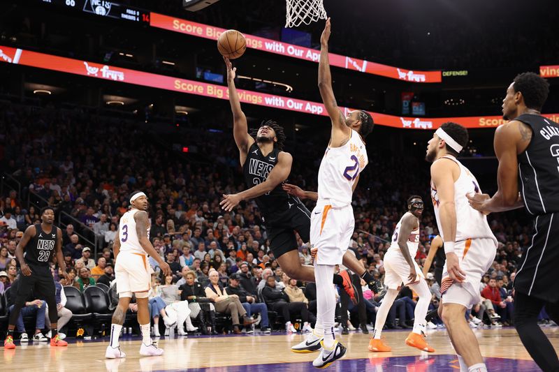 PHOENIX, ARIZONA - DECEMBER 13: Cam Thomas #24 of the Brooklyn Nets lays up a shot against Keita Bates-Diop #21 of the Phoenix Suns during the second half of the NBA game at Footprint Center on December 13, 2023 in Phoenix, Arizona. The Nets defeated the Suns 116-112. NOTE TO USER: User expressly acknowledges and agrees that, by downloading and or using this photograph, User is consenting to the terms and conditions of the Getty Images License Agreement.  (Photo by Christian Petersen/Getty Images)