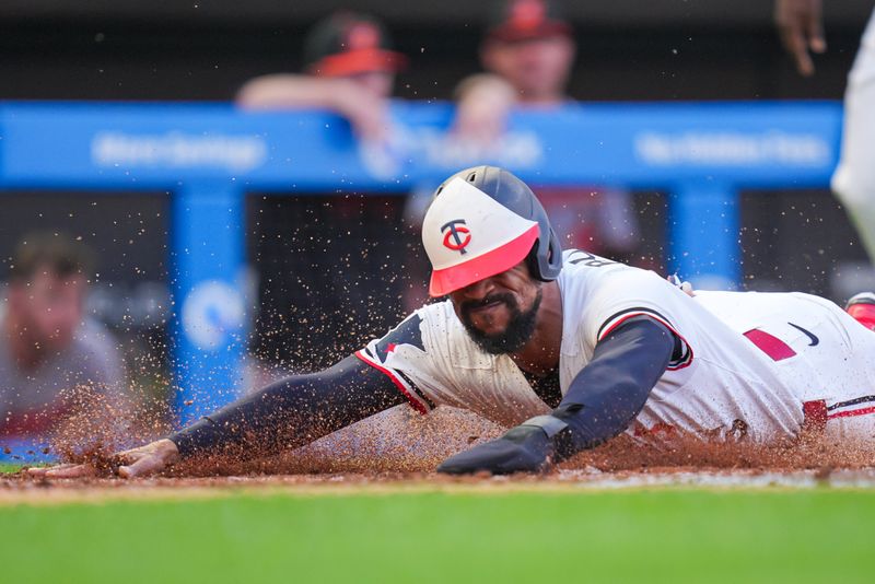 May 6, 2025; Minneapolis, Minnesota, USA; Minnesota Twins outfielder Byron Buxton (25) slides home against the Baltimore Orioles in the third inning at Target Field. Mandatory Credit: Brad Rempel-Imagn Images