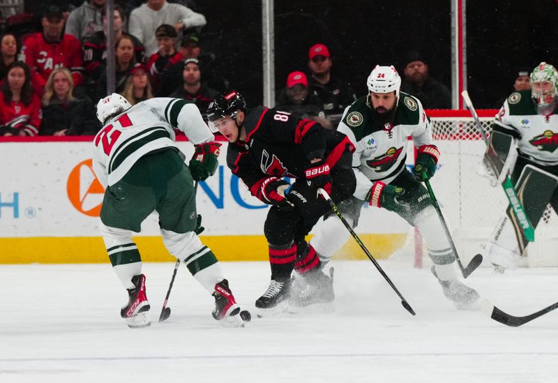 Jan 21, 2024; Raleigh, North Carolina, USA;  Minnesota Wild defenseman Zach Bogosian (24) and right wing Brandon Duhaime (21) defends against Carolina Hurricanes center Martin Necas (88) during the second period at PNC Arena. Mandatory Credit: James Guillory-USA TODAY Sports