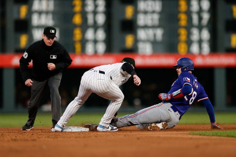 May 10, 2024; Denver, Colorado, USA; Texas Rangers catcher Jonah Heim (28) is tagged out attempting to reach second against Colorado Rockies second baseman Brendan Rodgers (7) in the sixth inning at Coors Field. Mandatory Credit: Isaiah J. Downing-USA TODAY Sports