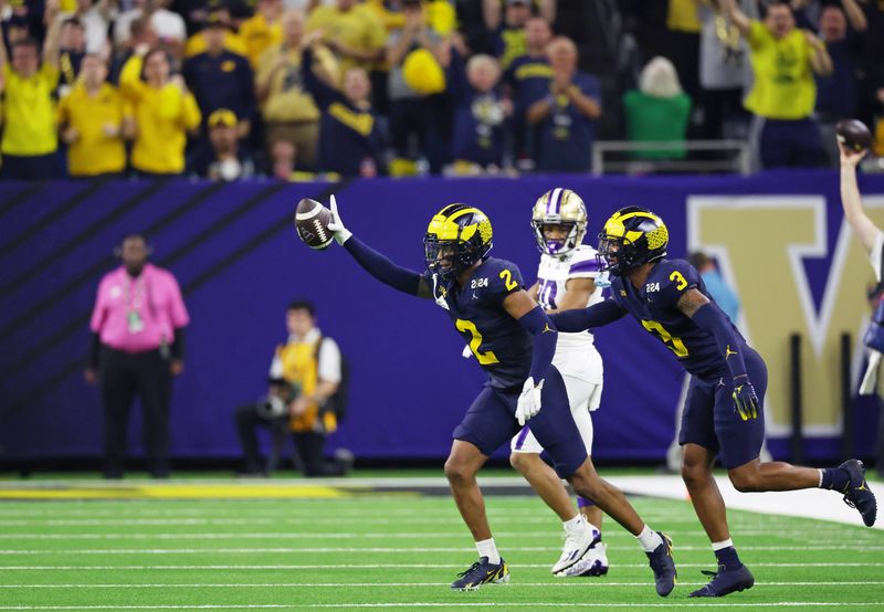 Jan 8, 2024; Houston, TX, USA; Michigan Wolverines defensive back Will Johnson (2) celebrates with defensive back Keon Sabb (3) after a turnover against the Washington Huskies during the third quarter in the 2024 College Football Playoff national championship game at NRG Stadium. Mandatory Credit: Thomas Shea-USA TODAY Sports