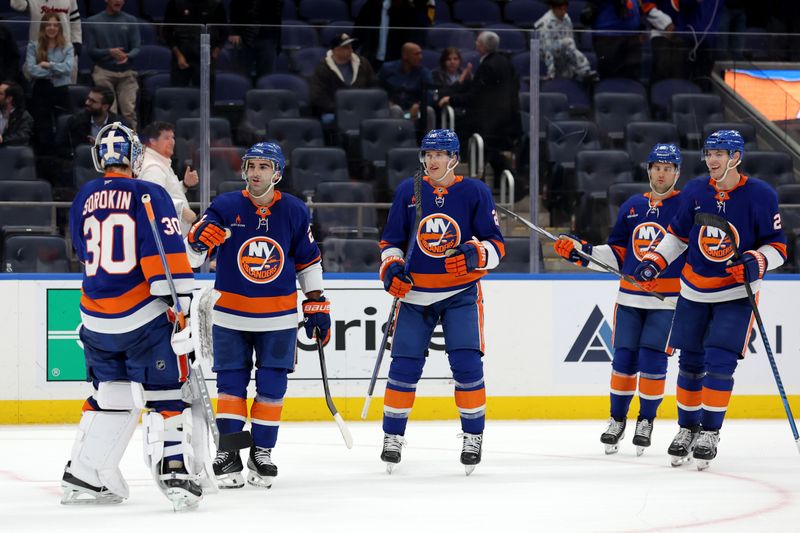 Nov 5, 2024; Elmont, New York, USA; New York Islanders goaltender Ilya Sorokin (30) celebrates with center Kyle Palmieri (21) after defeating the Pittsburgh Penguins in a shootout at UBS Arena. Mandatory Credit: Brad Penner-Imagn Images