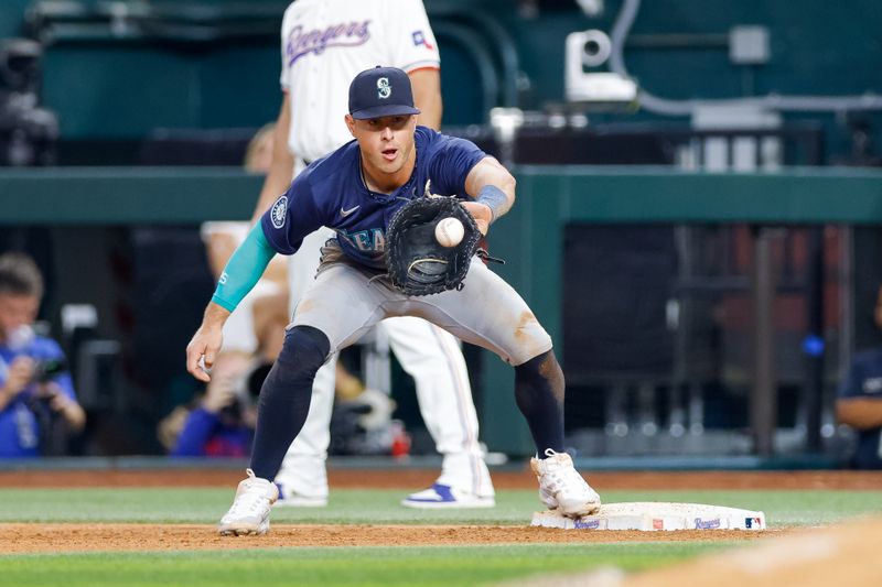 Sep 21, 2024; Arlington, Texas, USA; Seattle Mariners first baseman Dylan Moore (25) catches a throw over to first base during the seventh inning against the Texas Rangers at Globe Life Field. Mandatory Credit: Andrew Dieb-Imagn Images