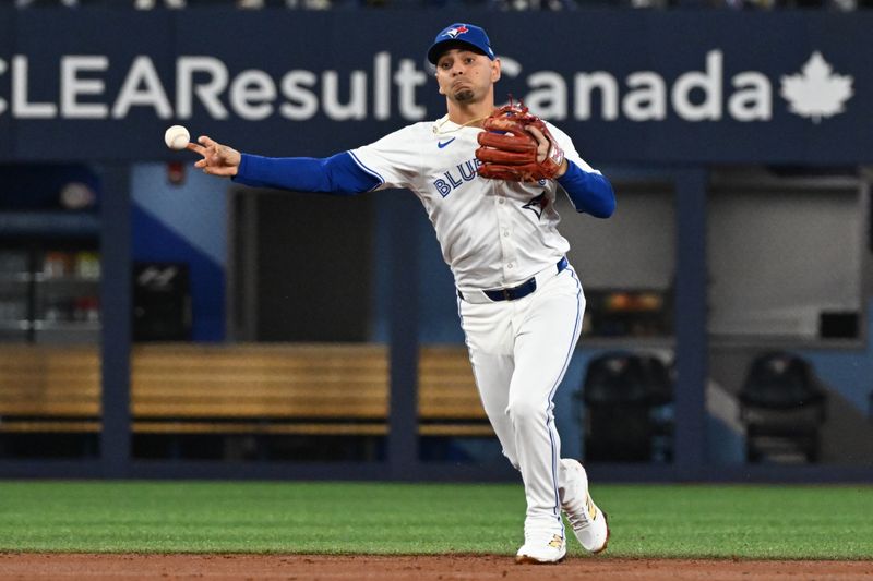 Sep 23, 2025; Toronto, Ontario, CAN;  Toronto Blue Jays shortstop Andres Gimenez (0) throws out Boston Red Sox center fielder Ceddanne Rafaela (not shown) in the second inning at Rogers Centre. Mandatory Credit: Dan Hamilton-Imagn Images