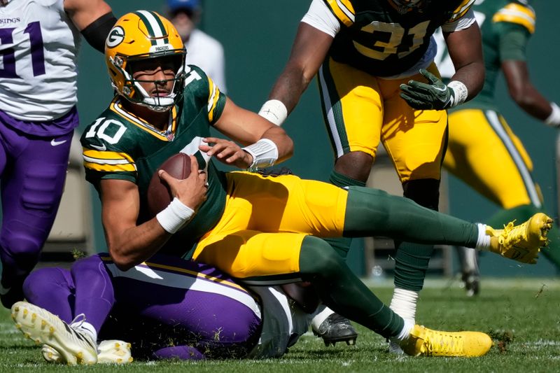 Green Bay Packers quarterback Jordan Love (10) is sacked by Minnesota Vikings linebacker Pat Jones II, below, during the first half of an NFL football game Sunday, Sept. 29, 2024, in Green Bay, Wis. (AP Photo/Morry Gash)