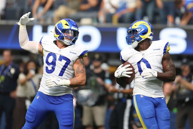 Los Angeles Rams linebacker Byron Young (0) celebrates with linebacker Michael Hoecht (97) during the second half of an NFL football game against the San Francisco 49ers, Sunday, Sept. 22, 2024, in Inglewood, Calif. (AP Photo/Ryan Sun)