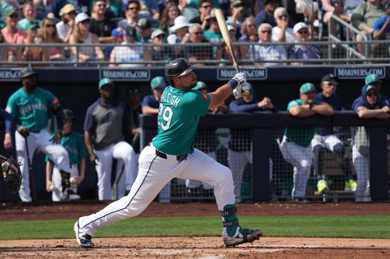 Feb 26, 2026; Peoria, Arizona, USA; Seattle Mariners catcher Cal Raleigh (29) hits an RBI sacrifice fly out against the Cleveland Guardians in the second inning at Peoria Sports Complex. Mandatory Credit: Rick Scuteri-Imagn Images