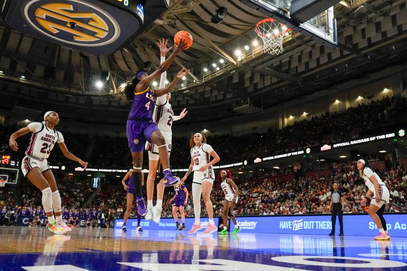 Mar 10, 2024; Greensville, SC, USA;  LSU Lady Tigers guard Flau'jae Johnson (4) on a fast break covered by South Carolina Gamecocks forward Sania Feagin (20) during the first half at Bon Secours Wellness Arena. Mandatory Credit: Jim Dedmon-USA TODAY Sports