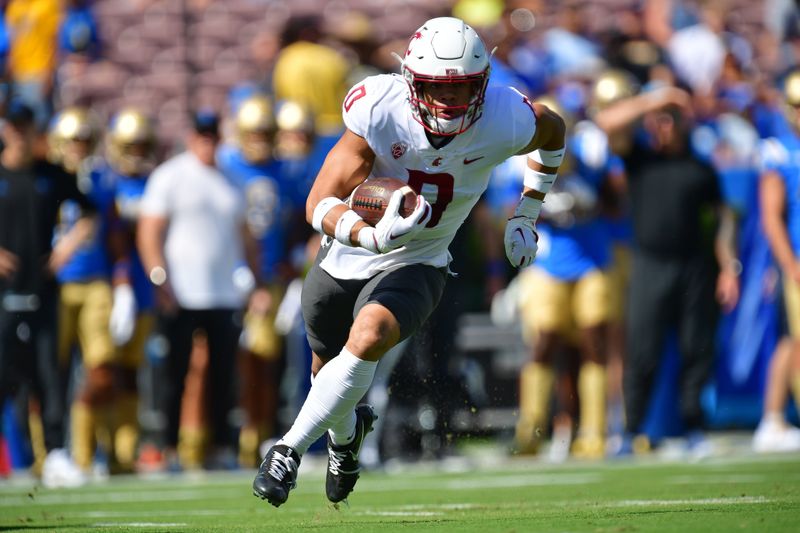 Oct 7, 2023; Pasadena, California, USA; Washington State Cougars defensive back Sam Lockett III (0) runs the ball after an interception against the UCLA Bruins during the first half at Rose Bowl. Mandatory Credit: Gary A. Vasquez-USA TODAY Sports