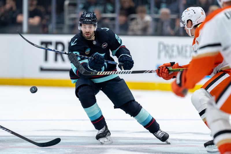 Jan 28, 2025; Seattle, Washington, USA;  Seattle Kraken forward Oliver Bjorkstrand (22) dumps the puck during the second period against the Anaheim Ducks at Climate Pledge Arena. Mandatory Credit: Stephen Brashear-Imagn Images