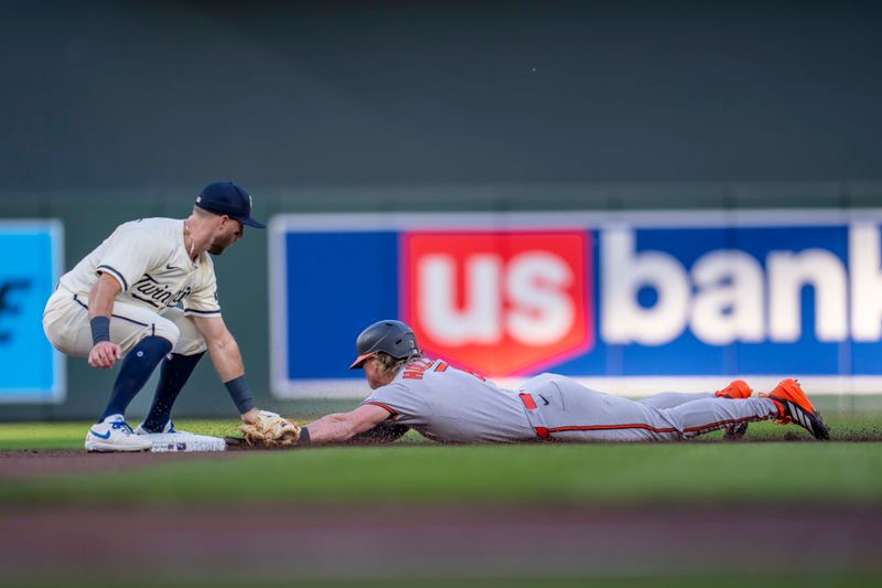 May 7, 2025; Minneapolis, Minnesota, USA; Minnesota Twins second baseman Kody Clemens (18) tags out Baltimore Orioles second baseman Jackson Holliday (7) attempting to steal second base in the second inning at Target Field. Mandatory Credit: Jesse Johnson-Imagn Images