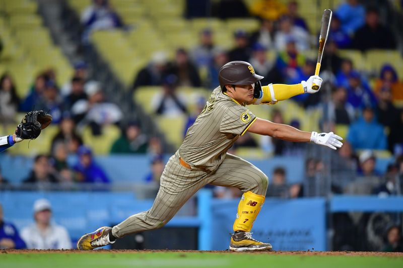 Apr 13, 2024; Los Angeles, California, USA; San Diego Padres shortstop Ha-Seong Kim (7) reaches first on a fielders choice against the Los Angeles Dodgers. during the ninth inning at Dodger Stadium. Mandatory Credit: Gary A. Vasquez-USA TODAY Sports