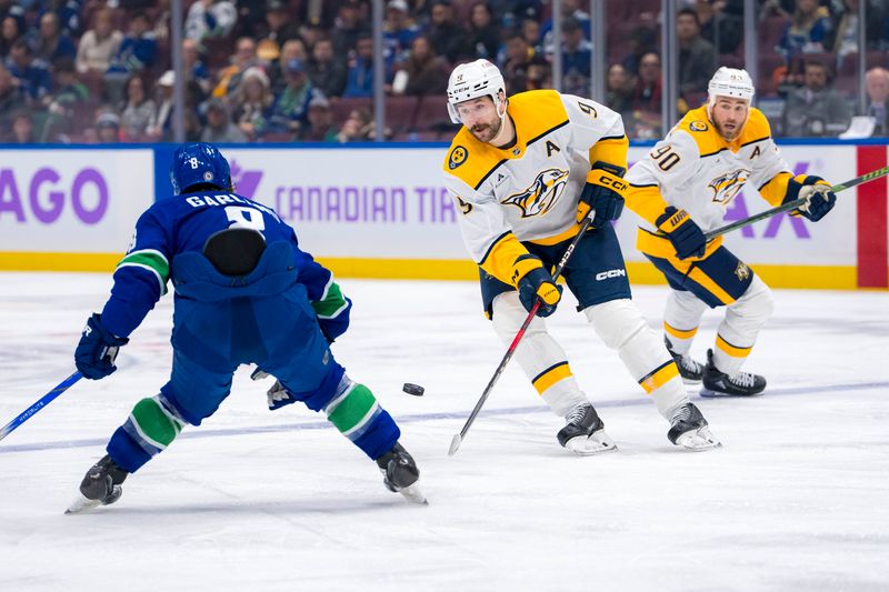 Nov 17, 2024; Vancouver, British Columbia, CAN; Nashville Predators forward Filip Forsberg (9) passes around Vancouver Canucks forward Conor Garland (8) during the second period at Rogers Arena. Mandatory Credit: Bob Frid-Imagn Images