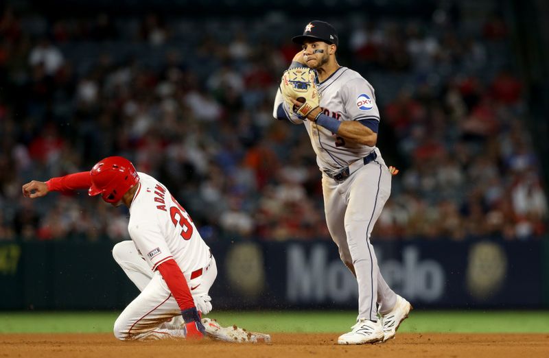 Sep 14, 2024; Anaheim, California, USA; Houston Astros shortstop Jeremy Pena (3) turns a double play to end the game during the 9th inning against Los Angeles Angels outfielder Jordyn Adams (39) at Angel Stadium. Mandatory Credit: Jason Parkhurst-Imagn Images