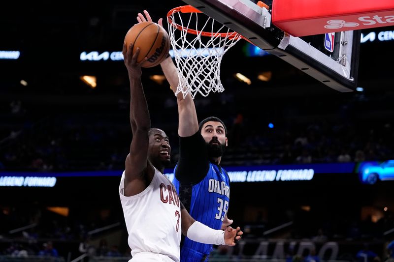 ORLANDO, FLORIDA - APRIL 25: Goga Bitadze #35 of the Orlando Magic blocks the shot of Caris LeVert #3 of the Cleveland Cavaliers during the fourth quarter of game three of the Eastern Conference First Round Playoffs at Kia Center on April 25, 2024 in Orlando, Florida. NOTE TO USER: User expressly acknowledges and agrees that, by downloading and or using this photograph, User is consenting to the terms and conditions of the Getty Images License Agreement. (Photo by Rich Storry/Getty Images)