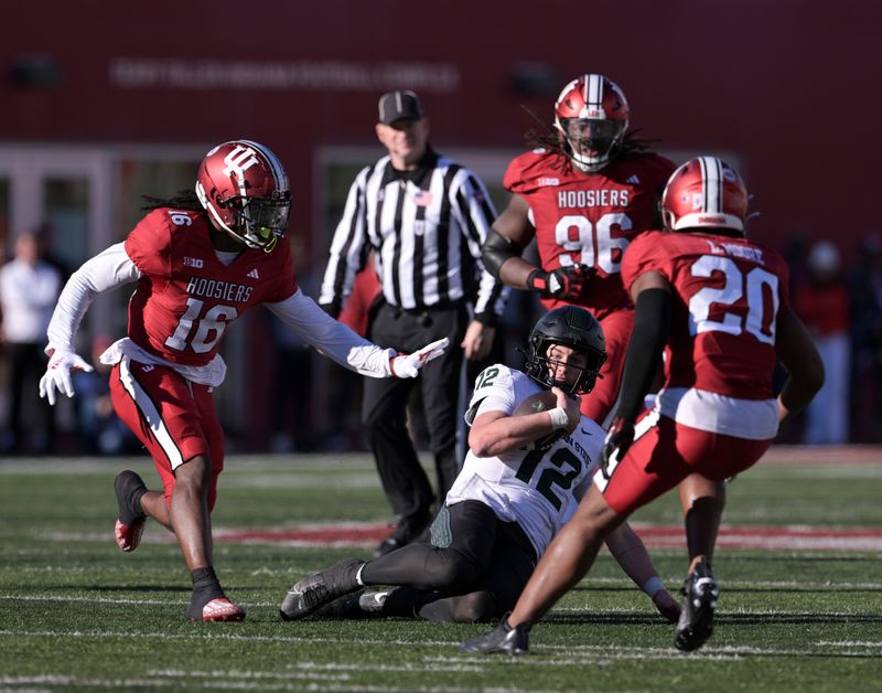 Nov 18, 2023; Bloomington, Indiana, USA; Michigan State Spartans quarterback Katin Houser (12) slides to prevent a tackle during the second half against the Indiana Hoosiers at Memorial Stadium. Mandatory Credit: Marc Lebryk-USA TODAY Sports