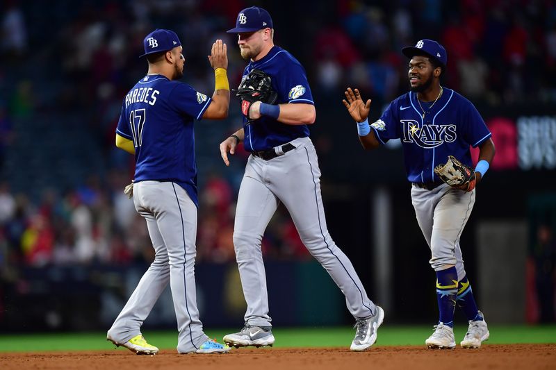 Aug 18, 2023; Anaheim, California, USA; Tampa Bay Rays second baseman Isaac Paredes (17) center fielder Luke Raley (55) and shortstop Osleivis Basabe (37) celebrate the victory against the Los Angeles Angels at Angel Stadium. Mandatory Credit: Gary A. Vasquez-USA TODAY Sports