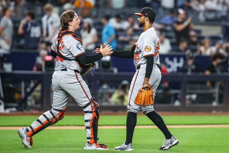 Jun 19, 2024; Bronx, New York, USA;  Baltimore Orioles catcher Adley Rutschman (35) congratulates relief pitcher Dillon Tate (55) after recording a save to defeat the New York Yankees 7-6 in ten innings at Yankee Stadium. Mandatory Credit: Wendell Cruz-USA TODAY Sports