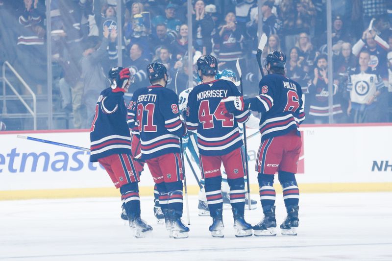 Oct 18, 2024; Winnipeg, Manitoba, CAN;  Winnipeg Jets defenseman Josh Morrissey (44) is congratulated by his teammates on his goal against the San Jose Sharks during the first period at Canada Life Centre. Mandatory Credit: Terrence Lee-Imagn Images