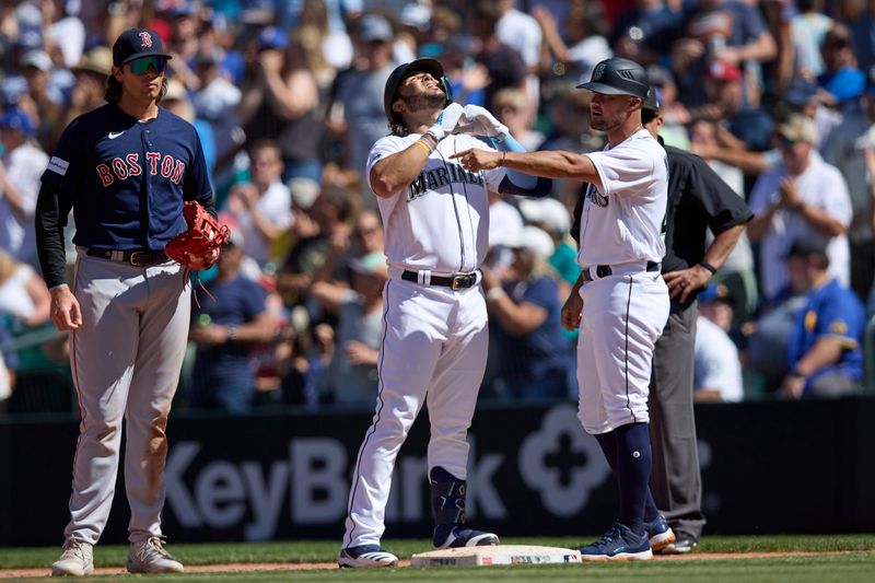 Aug 2, 2023; Seattle, Washington, USA; Seattle Mariners  Eugenio Suarez celebrates his RBI single with first base coach Kristopher Negr n during the seventh inning against the with Boston Red Sox first baseman at T-Mobile Park. Mandatory Credit: John Froschauer-USA TODAY Sports