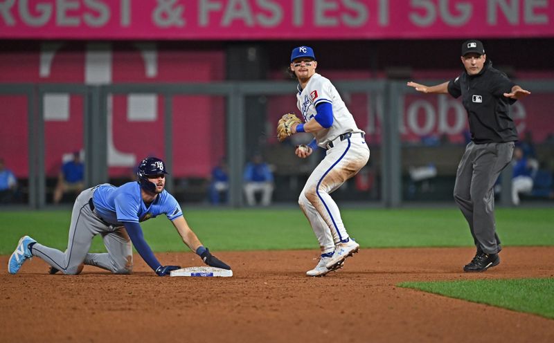 Jul 3, 2024; Kansas City, Missouri, USA;  Kansas City Royals shortstop Bobby Witt Jr. (7) looks to third as Tampa Bay Rays right fielder Josh Lowe (15) steals second base in the eighth inning at Kauffman Stadium. Mandatory Credit: Peter Aiken-USA TODAY Sports