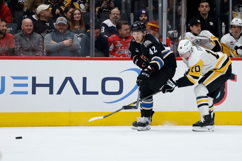 Jan 18, 2025; Washington, District of Columbia, USA; Washington Capitals defenseman Martin Fehervary (42) and Pittsburgh Penguins left wing Drew O'Connor (10) battle for the puck in the second period at Capital One Arena. Mandatory Credit: Geoff Burke-Imagn Images