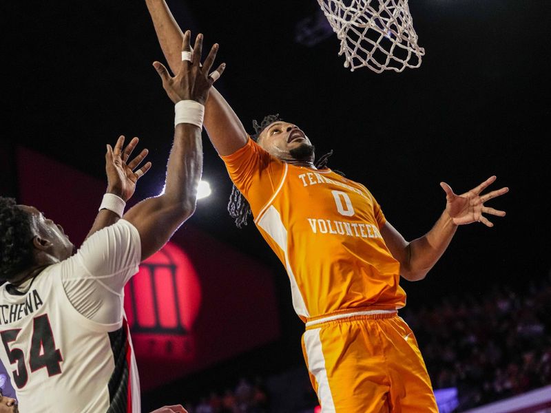 Jan 13, 2024; Athens, Georgia, USA; Tennessee Volunteers forward Jonas Aidoo (0) scores a basket past Georgia Bulldogs center Russel Tchewa (54) during the first half at Stegeman Coliseum. Mandatory Credit: Dale Zanine-USA TODAY Sports