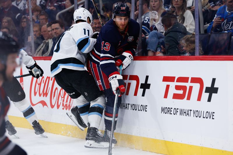 Oct 26, 2025; Winnipeg, Manitoba, CAN; Winnipeg Jets forward Gabriel Vilardi (13) avoids a check from Utah Mammoth forward forward Dylan Guenther (11) during the first period at Canada Life Centre. Mandatory Credit: Terrence Lee-Imagn Images