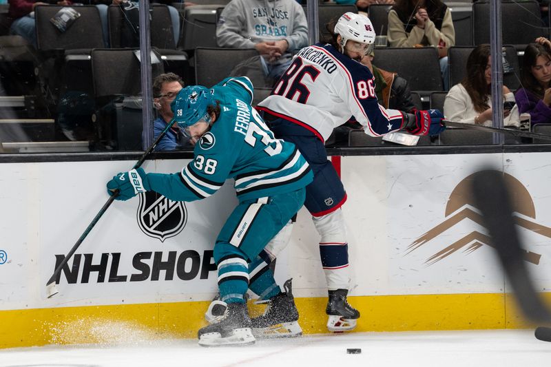 Nov 5, 2024; San Jose, California, USA;  San Jose Sharks defenseman Mario Ferraro (38) and Columbus Blue Jackets right wing Kirill Marchenko (86) battle for the puck against the boards during the first period at SAP Center at San Jose. Mandatory Credit: Neville E. Guard-Imagn Images