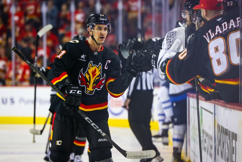 Oct 26, 2024; Calgary, Alberta, CAN; Calgary Flames center Mikael Backlund (11) celebrates his goal with teammates against the Winnipeg Jets during the first period at Scotiabank Saddledome. Mandatory Credit: Sergei Belski-Imagn Images