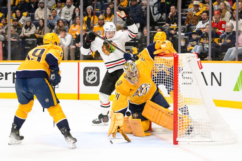 Jan 16, 2025; Nashville, Tennessee, USA;  Chicago Blackhawks defenseman Alec Martinez (25) shoots from the blue and with funny bounces scores past Nashville Predators goaltender Juuse Saros (74) during the second period at Bridgestone Arena. Mandatory Credit: Steve Roberts-Imagn Images