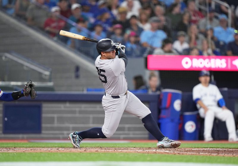 Jun 30, 2024; Toronto, Ontario, CAN; New York Yankees second baseman Gleyber Torres (25) hits a single against the Toronto Blue Jays during the fifth inning at Rogers Centre. Mandatory Credit: Nick Turchiaro-USA TODAY Sports