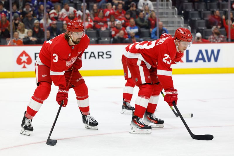 Dec 1, 2024; Detroit, Michigan, USA;  Detroit Red Wings defenseman Justin Holl (3) and left wing Lucas Raymond (23) gets set during a face off in the third period against the Vancouver Canucks at Little Caesars Arena. Mandatory Credit: Rick Osentoski-Imagn Images