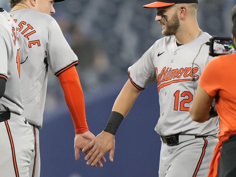 Jun 4, 2024; Toronto, Ontario, CAN;  Baltimore Orioles first baseman Ryan Mountcastle (6) and second baseman Connor Norby (12) celebrate a win over the Toronto Blue Jays at Rogers Centre. Mandatory Credit: John E. Sokolowski-USA TODAY Sports