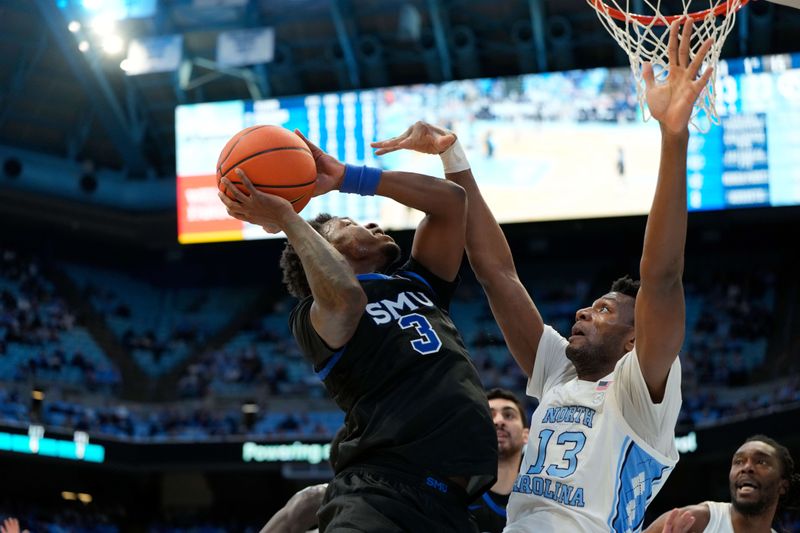 Jan 7, 2025; Chapel Hill, North Carolina, USA; Southern Methodist Mustangs guard Chuck Harris (3) shoots as North Carolina Tar Heels forward Jalen Washington (13) defends in the first half at Dean E. Smith Center. Mandatory Credit: Bob Donnan-Imagn Images