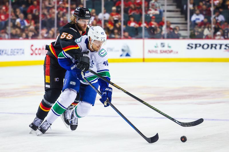 Dec 2, 2023; Calgary, Alberta, CAN; Vancouver Canucks center Elias Pettersson (40) and Calgary Flames defenseman Noah Hanifin (55) battle for the puck during the first period at Scotiabank Saddledome. Mandatory Credit: Sergei Belski-USA TODAY Sports